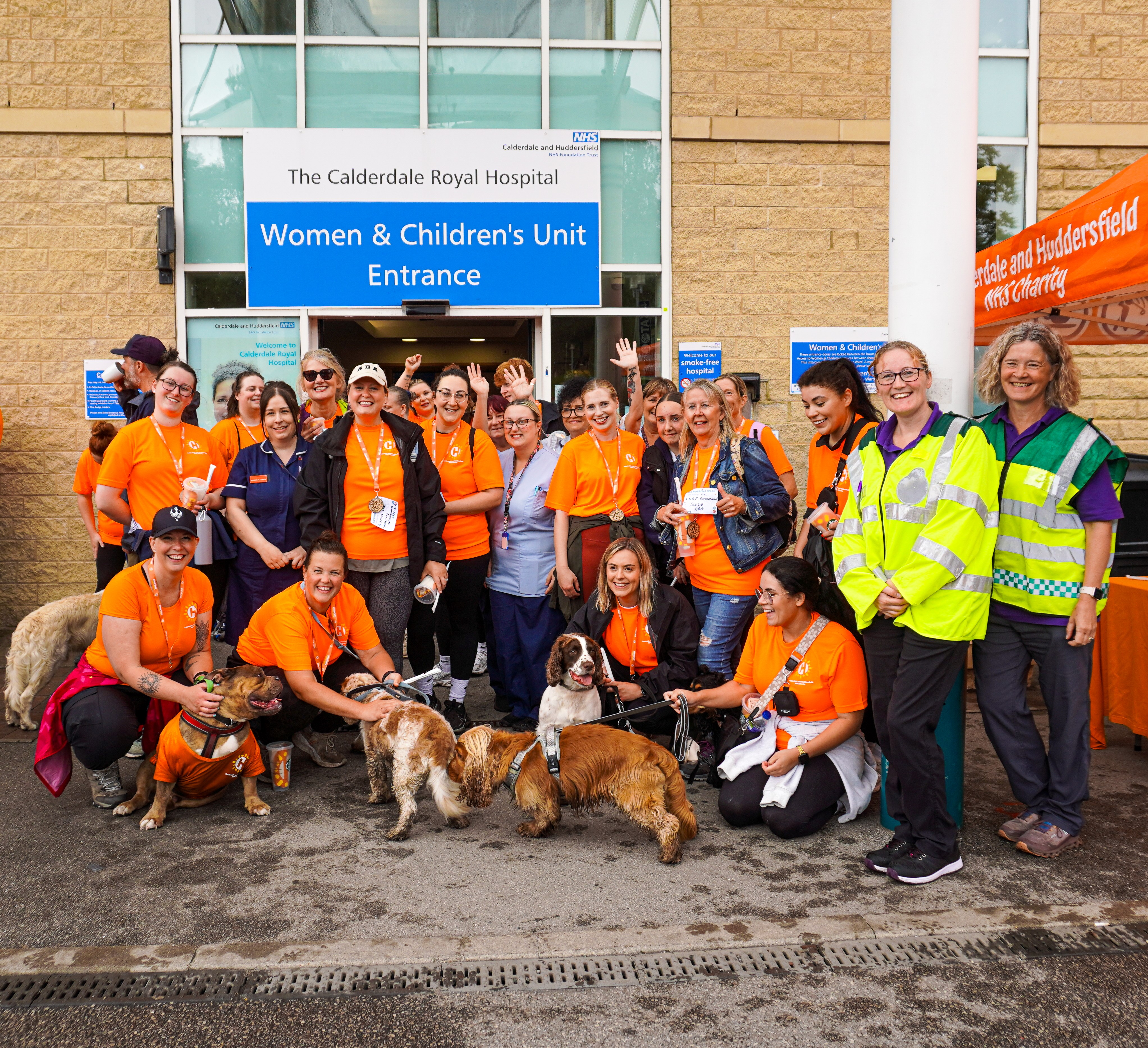 Group of people in orange t-shirts outside hospital entrance