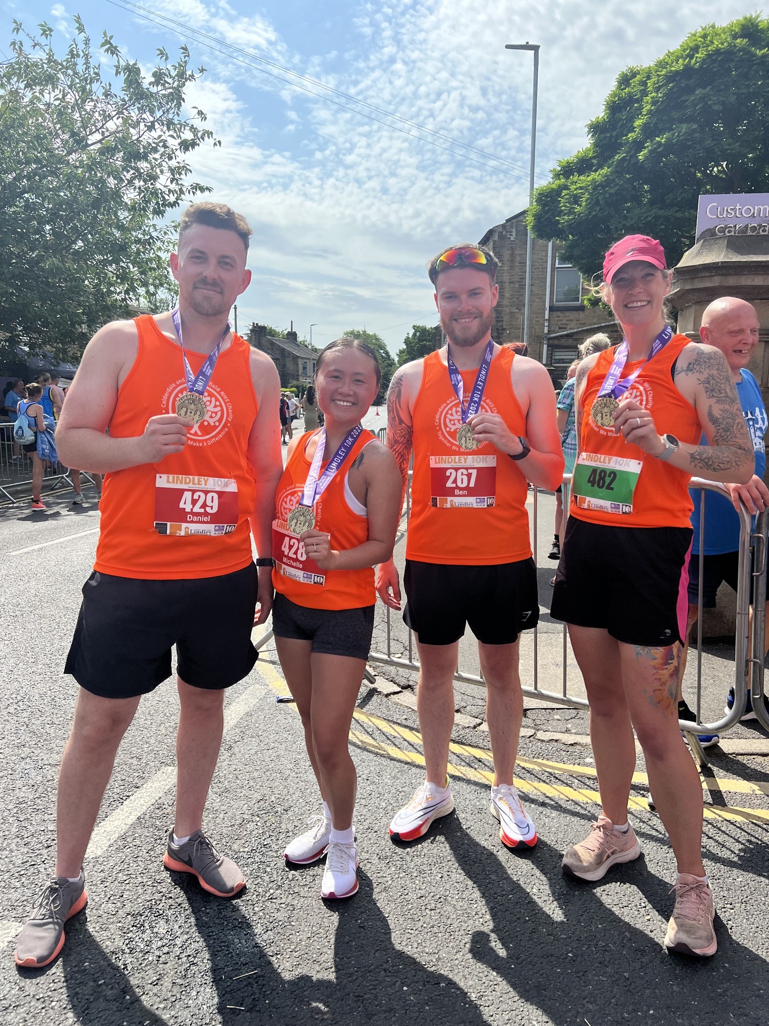 Group of runners smiling and showing their medals to the camera