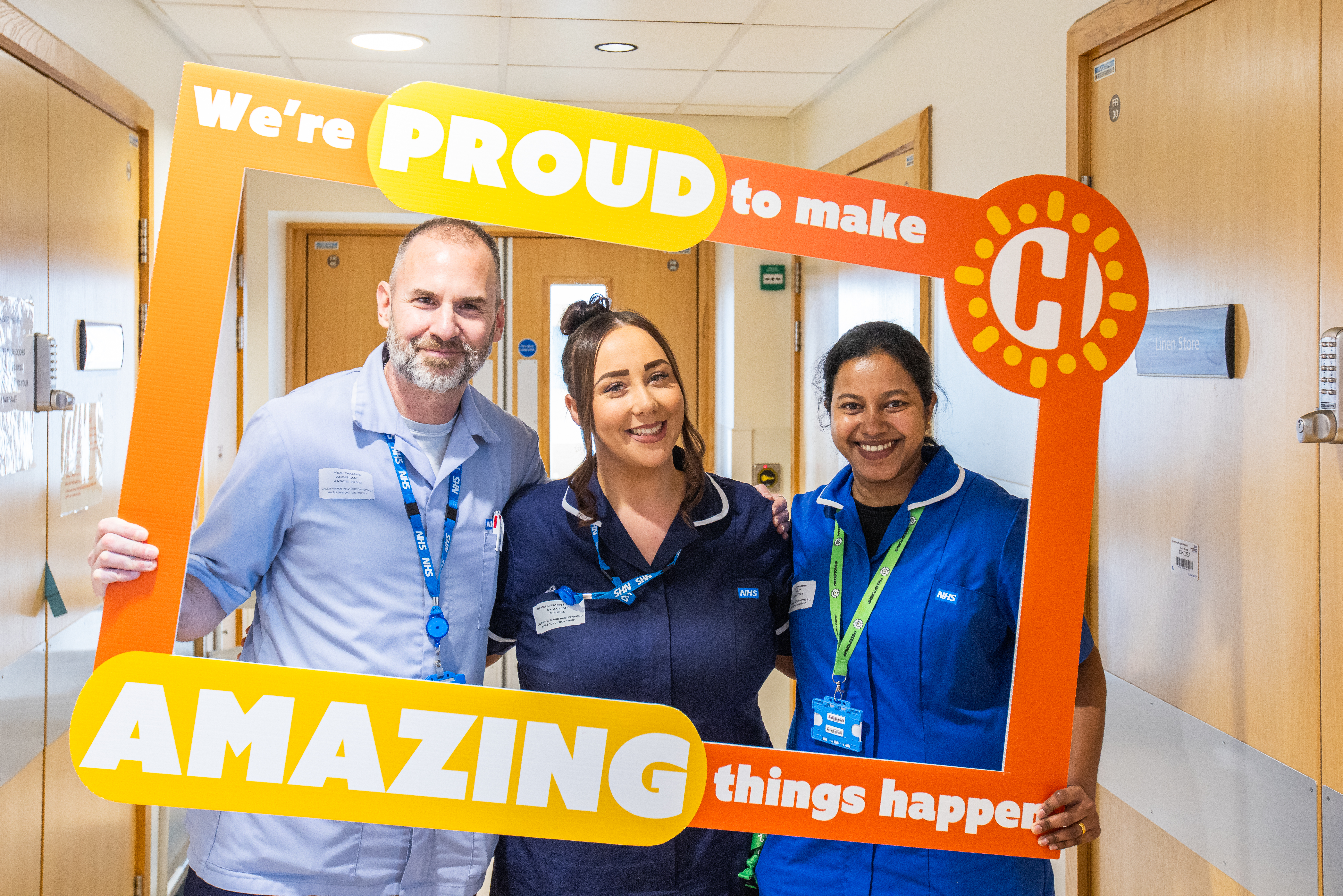 Colleagues posing with the charity selfie frame